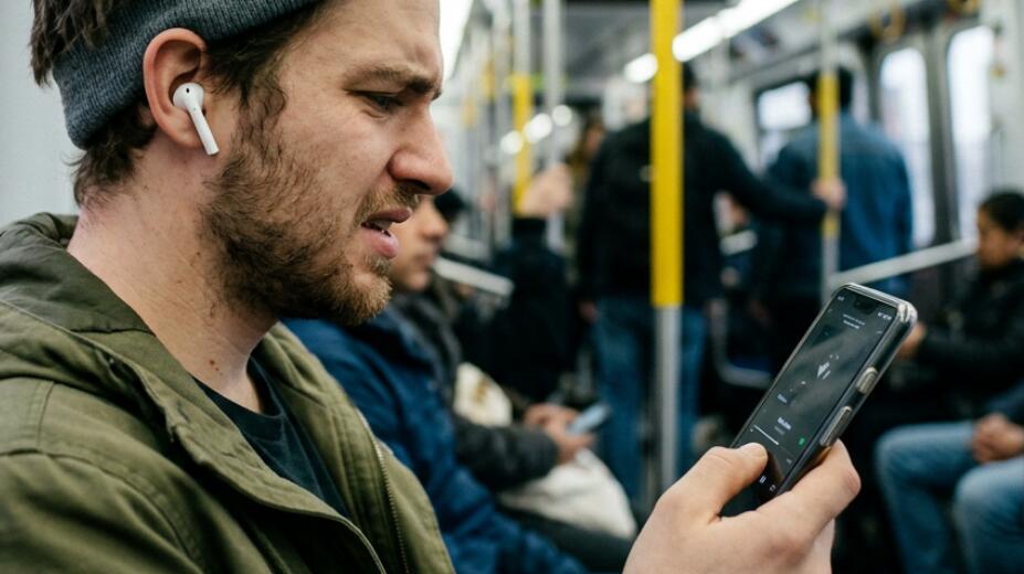 A girl wears earbuds to listen to music on the phone