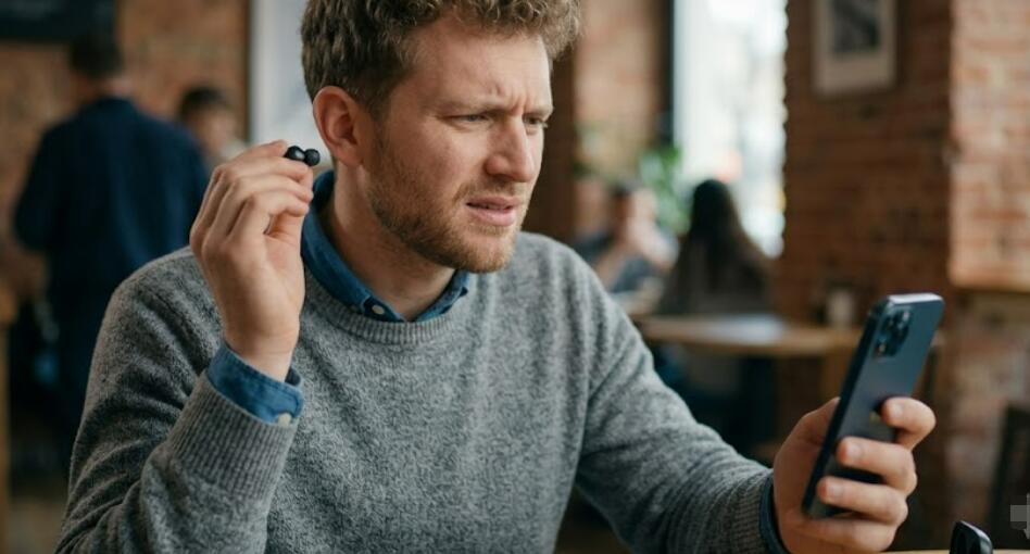 A guy takes an earbud