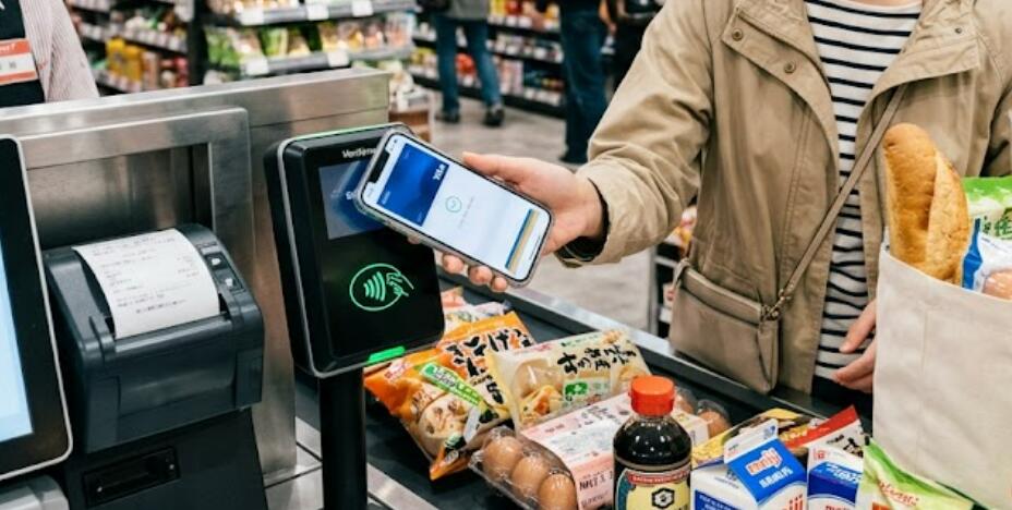 A lady uses NFC to pay in the supermarket