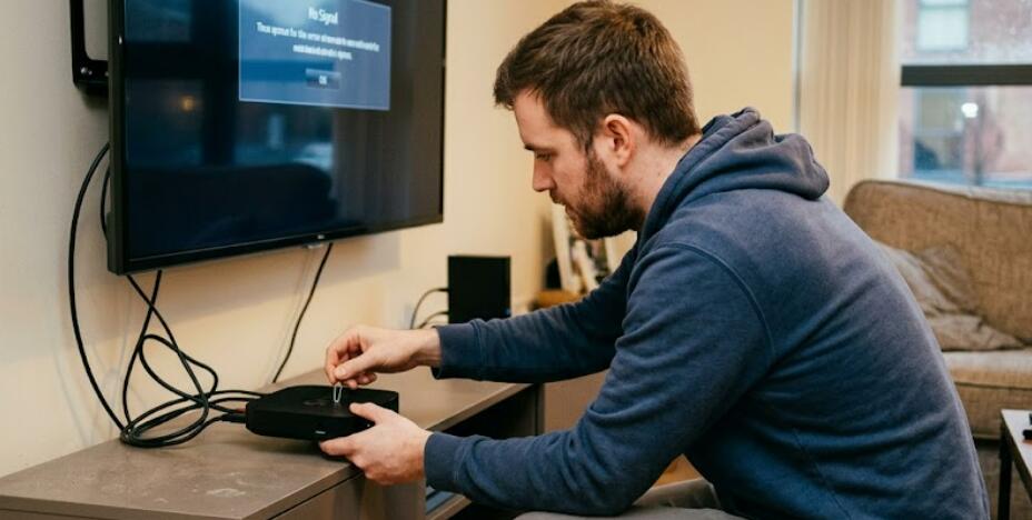A man tries to reset the TV box