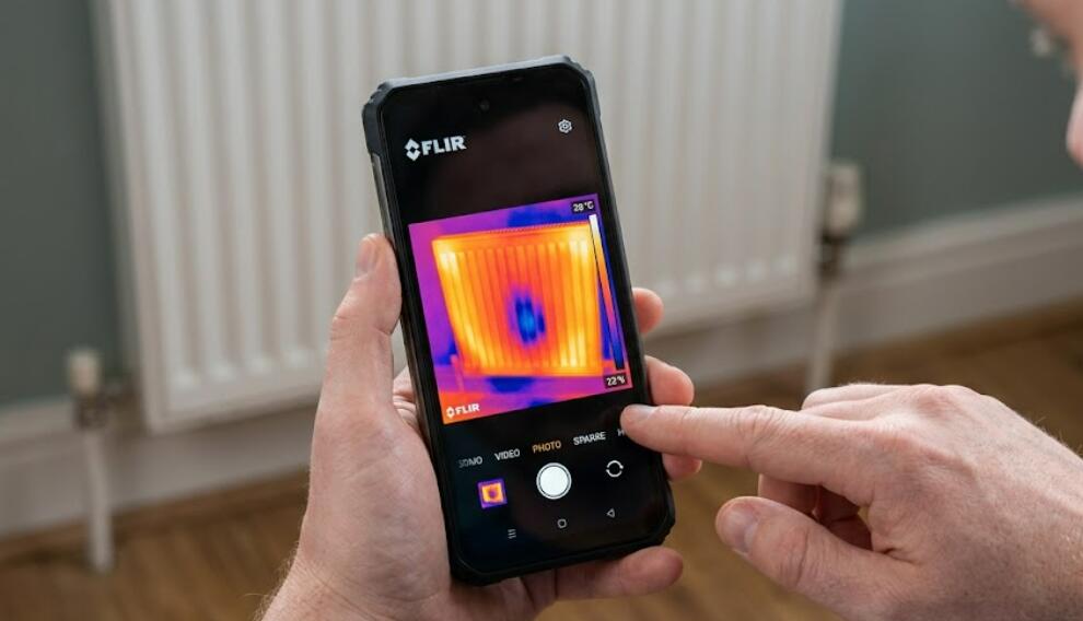 A man use Blackview BL9000 Pro thermal phone to scan the radiator